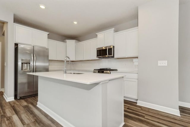 kitchen with stainless steel appliances, sink, a center island with sink, and white cabinets