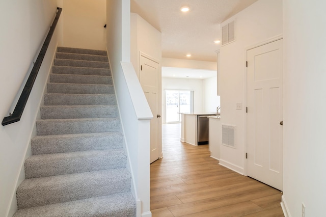 stairs featuring wood-type flooring