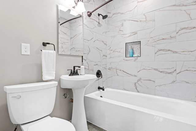 bathroom with tiled shower / bath combo and toilet