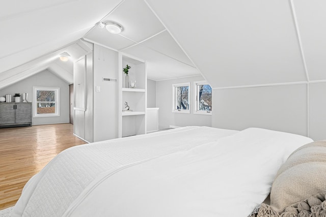 bedroom with lofted ceiling and light wood-type flooring