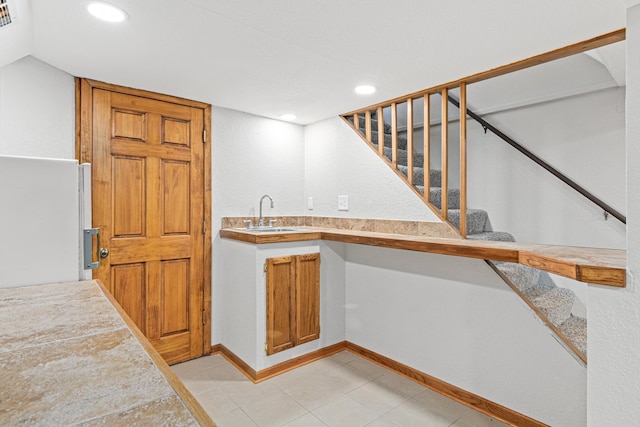 kitchen featuring white fridge, sink, and tile counters