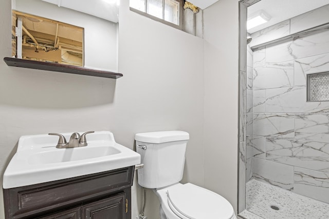 bathroom with vanity, toilet, and a tile shower