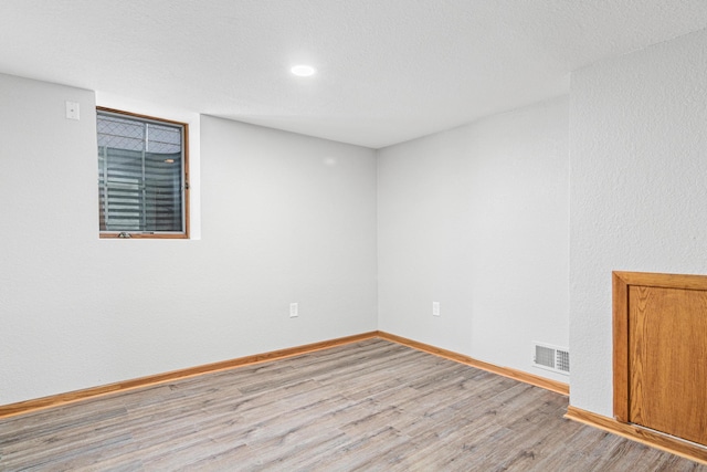 empty room featuring light hardwood / wood-style floors and a textured ceiling