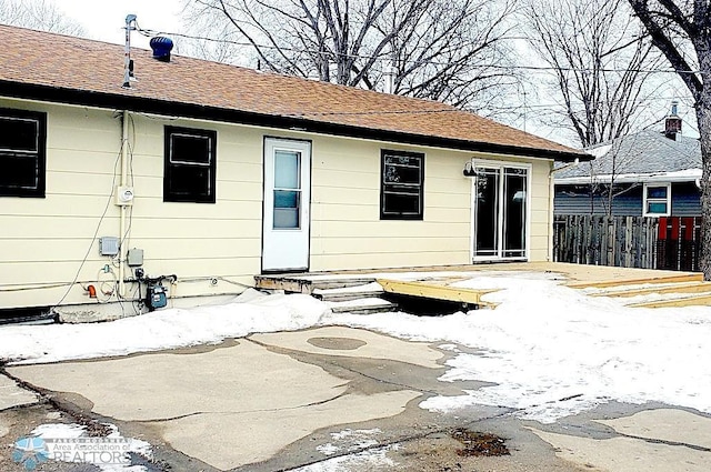 snow covered property entrance with a patio area