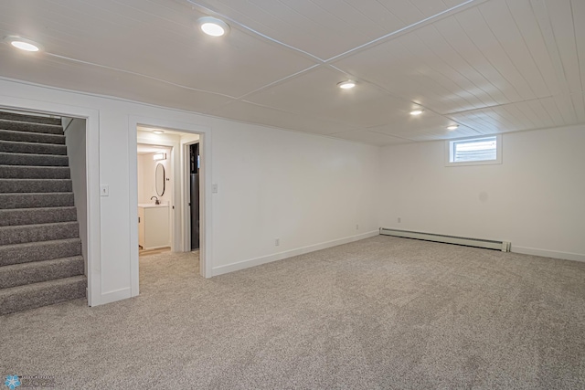 basement featuring a baseboard heating unit and light carpet