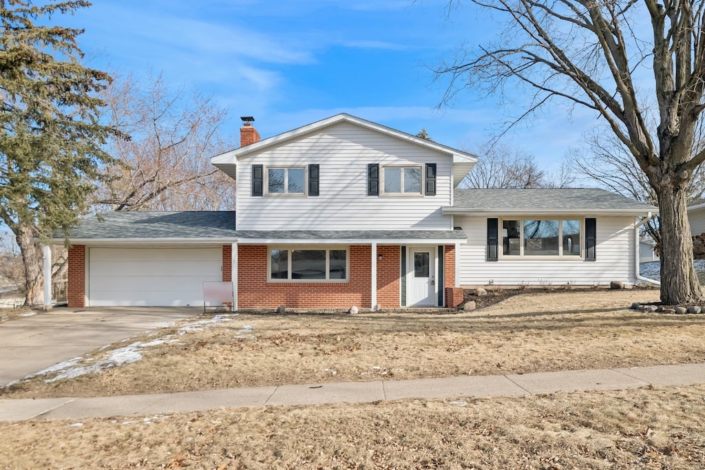 tri-level home featuring a garage and a front yard