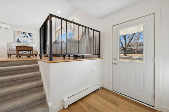 entryway featuring hardwood / wood-style flooring, a wall unit AC, and baseboard heating