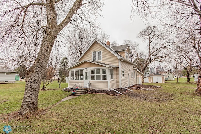 rear view of property with a sunroom and a yard