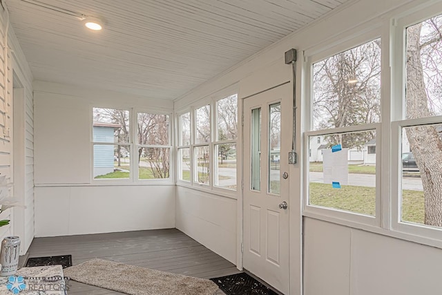 unfurnished sunroom featuring a healthy amount of sunlight and wooden ceiling