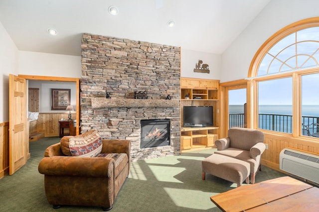 carpeted living room with built in shelves, an AC wall unit, a stone fireplace, and wood walls