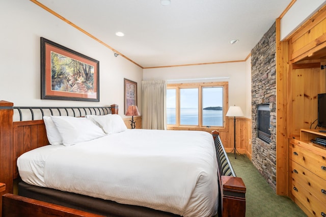 bedroom featuring dark carpet, a fireplace, and ornamental molding