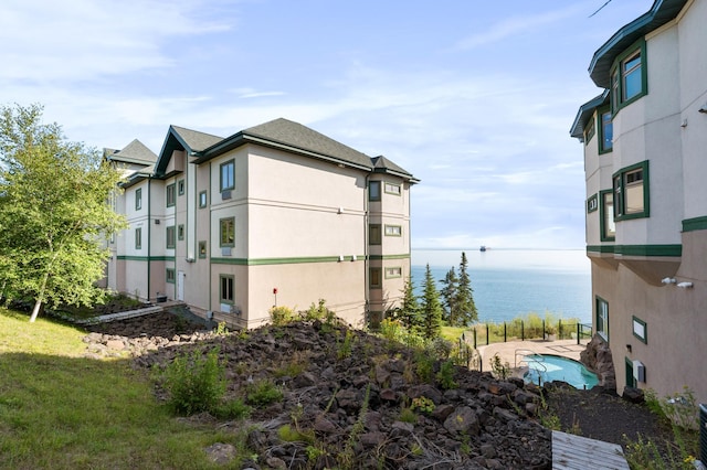 view of side of home featuring a lawn and a water view