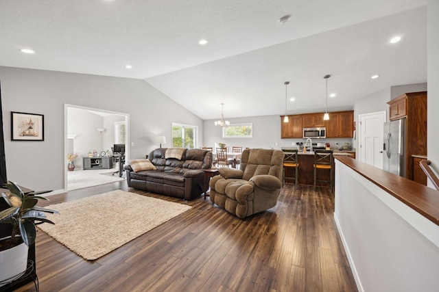 living room with vaulted ceiling, dark wood-type flooring, and an inviting chandelier