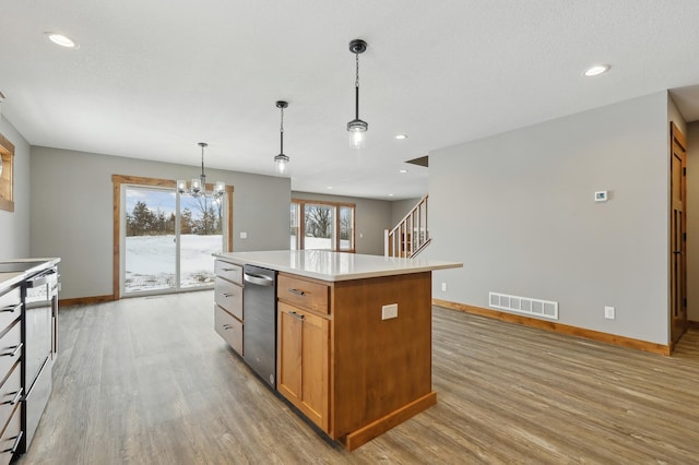 kitchen featuring a notable chandelier, decorative light fixtures, light hardwood / wood-style flooring, and a kitchen island