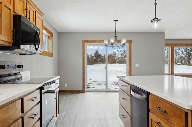 kitchen with pendant lighting, light hardwood / wood-style floors, stainless steel range with electric cooktop, and a notable chandelier