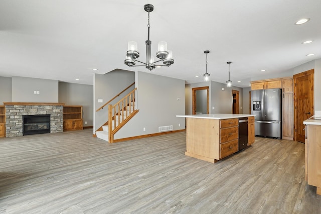 kitchen with pendant lighting, light hardwood / wood-style flooring, a center island, and appliances with stainless steel finishes