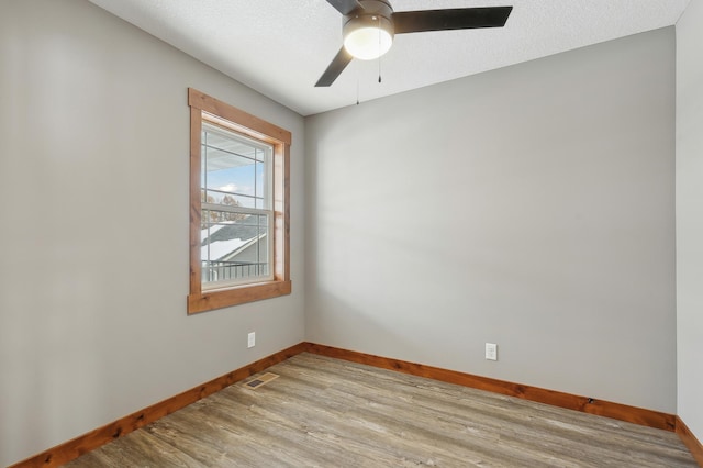 unfurnished room with ceiling fan, light hardwood / wood-style floors, and a textured ceiling