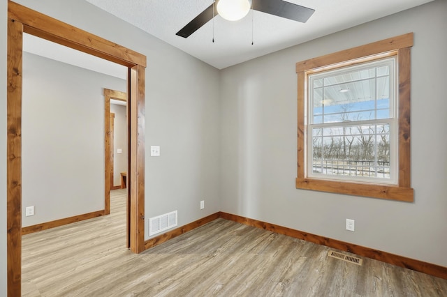 spare room with ceiling fan and light wood-type flooring