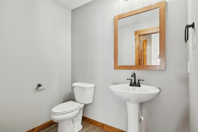 bathroom with wood-type flooring, toilet, and sink