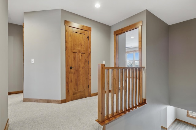 hallway featuring light colored carpet