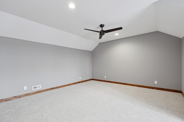 unfurnished room with vaulted ceiling, ceiling fan, and carpet