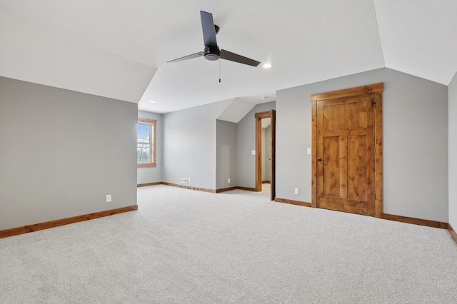 additional living space with lofted ceiling, light carpet, and ceiling fan