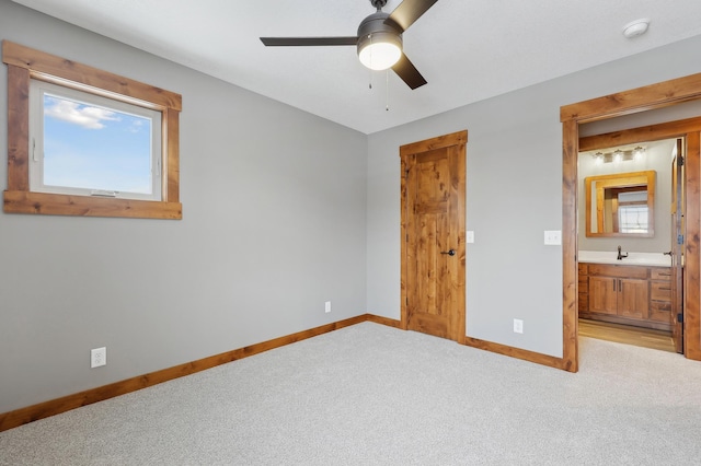 unfurnished bedroom featuring sink, light colored carpet, and ceiling fan