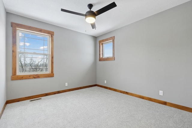 empty room featuring ceiling fan and carpet