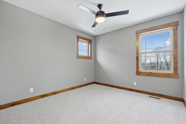 unfurnished room with ceiling fan and carpet