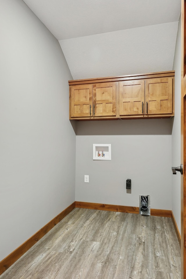 laundry room featuring cabinets, hookup for a washing machine, electric dryer hookup, and light hardwood / wood-style flooring