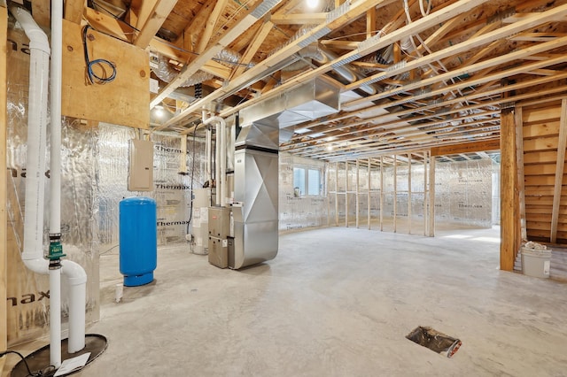 basement featuring heating unit, electric panel, and water heater