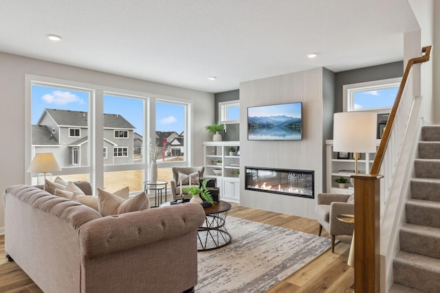 living room with a wealth of natural light and light hardwood / wood-style flooring