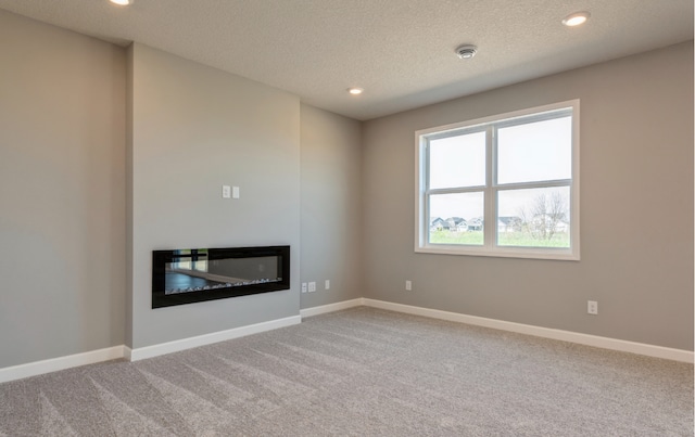 unfurnished living room with carpet and a textured ceiling