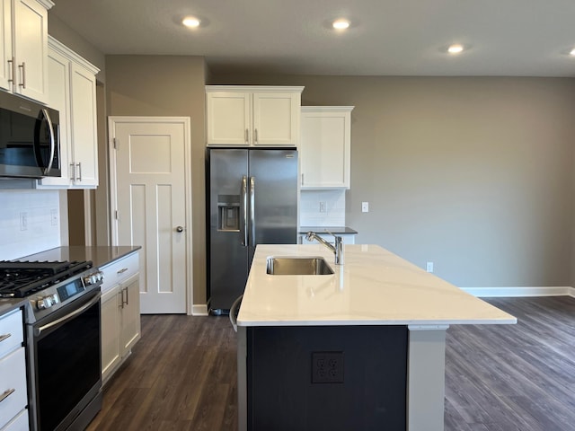 kitchen with tasteful backsplash, stainless steel appliances, sink, and a kitchen island with sink