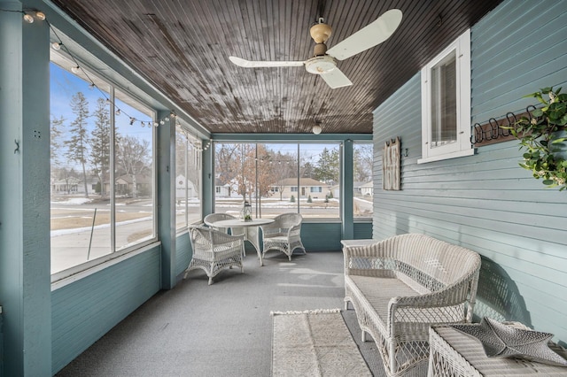 sunroom / solarium featuring wood ceiling and a ceiling fan