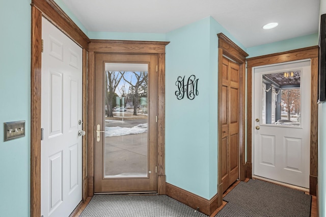 doorway featuring a wealth of natural light and baseboards