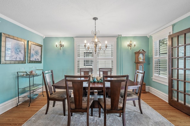 dining area featuring plenty of natural light, crown molding, and wood finished floors