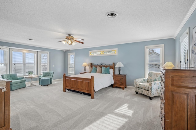 bedroom featuring baseboards, visible vents, a textured ceiling, crown molding, and light carpet