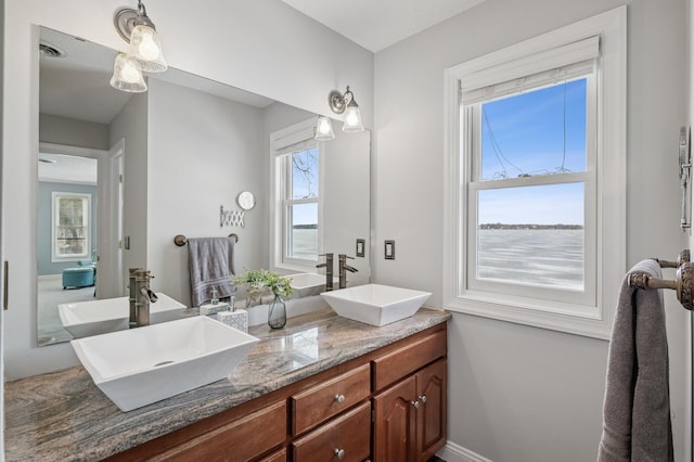 full bathroom with double vanity, visible vents, and a sink