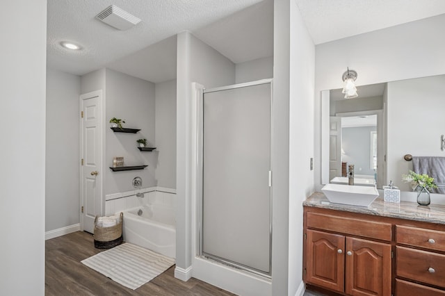 full bath with visible vents, wood finished floors, a shower stall, a bath, and vanity