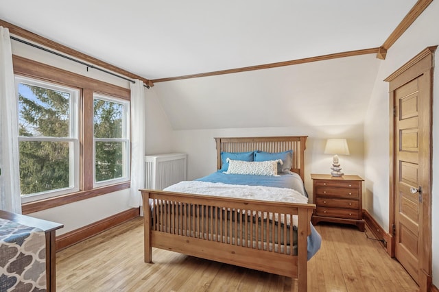 bedroom with light wood-type flooring, baseboards, and vaulted ceiling