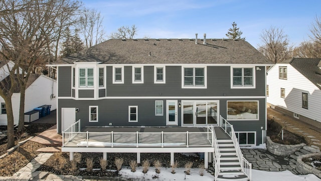 rear view of property with a wooden deck, stairs, and a shingled roof