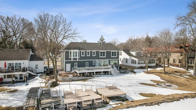 snow covered property featuring a wooden deck and stairs