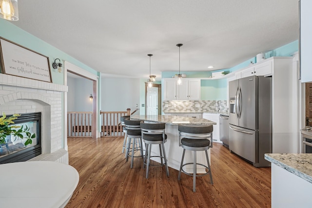 255 Shore Dr, Forest Lake, MN 55025 - kitchen with stainless steel appliances, white cabinets, backsplash, and dark wood-style flooring
