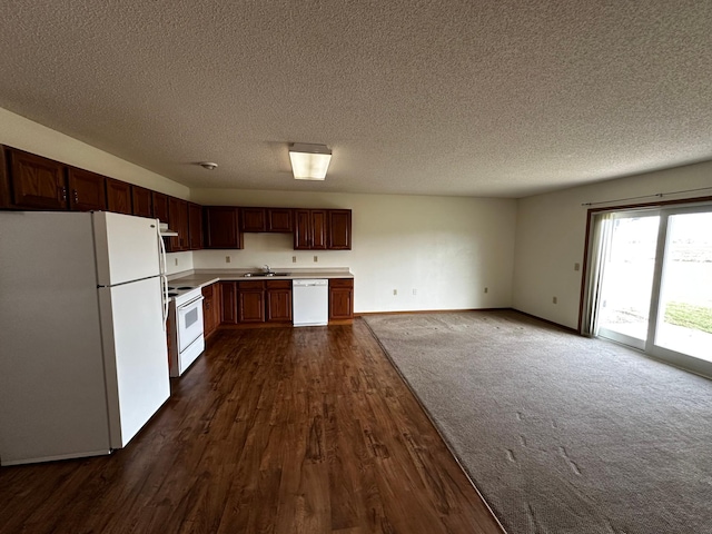 kitchen featuring white appliances, dark hardwood / wood-style flooring, sink, and a textured ceiling