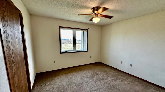 empty room featuring ceiling fan, carpet, and a textured ceiling