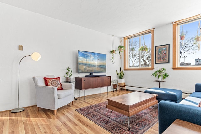 living room with baseboard heating, wood-type flooring, and a textured ceiling