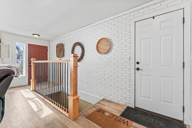 entrance foyer featuring light hardwood / wood-style flooring and brick wall