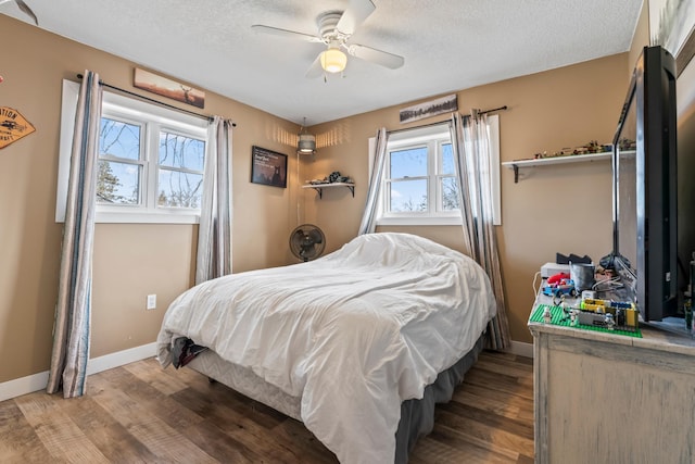 bedroom with hardwood / wood-style floors, a textured ceiling, and ceiling fan