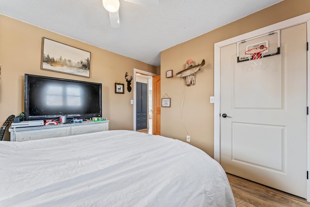 bedroom featuring light hardwood / wood-style flooring, ceiling fan, and a closet